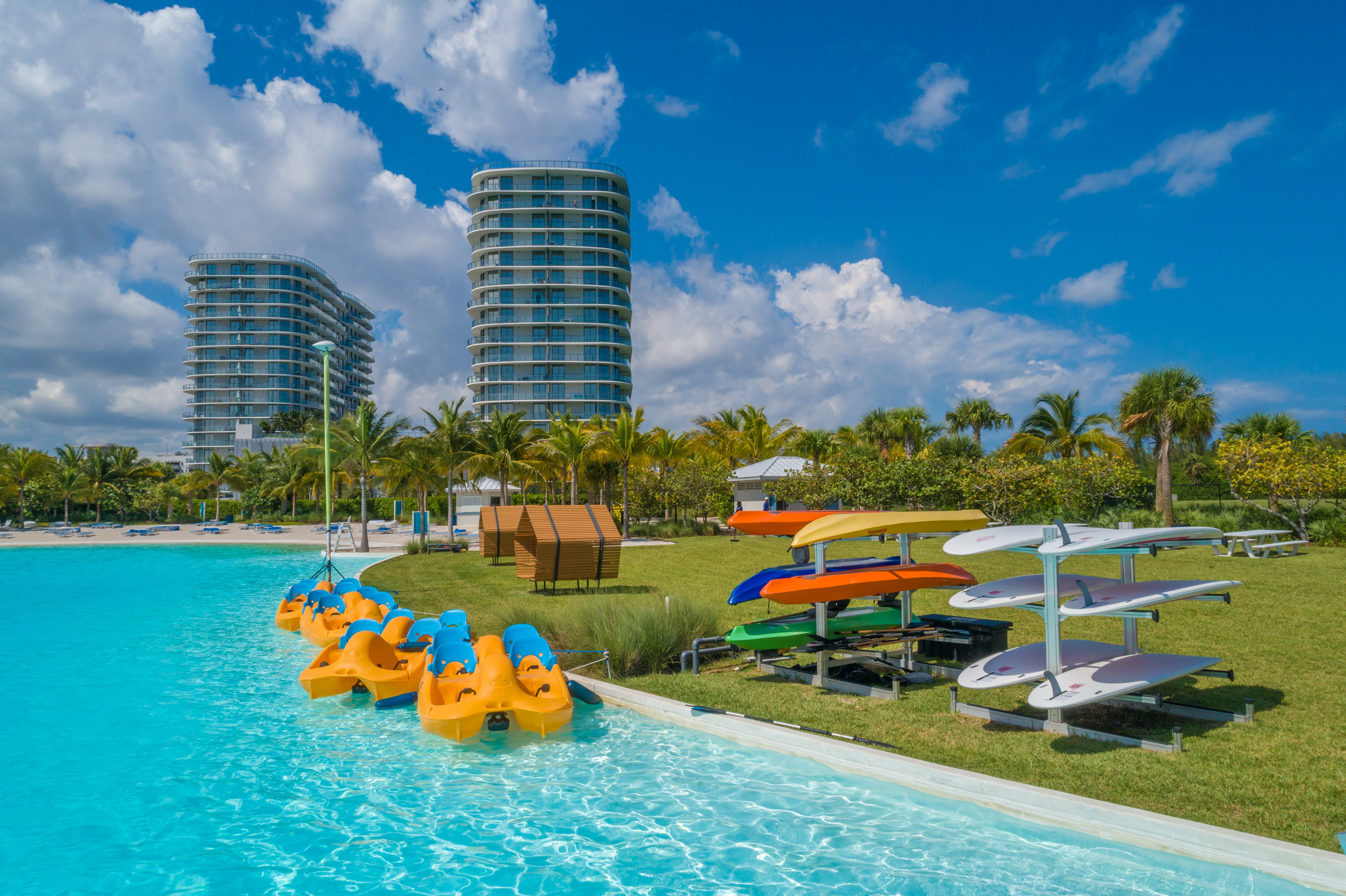 A pool with floating objects and a building in the background.